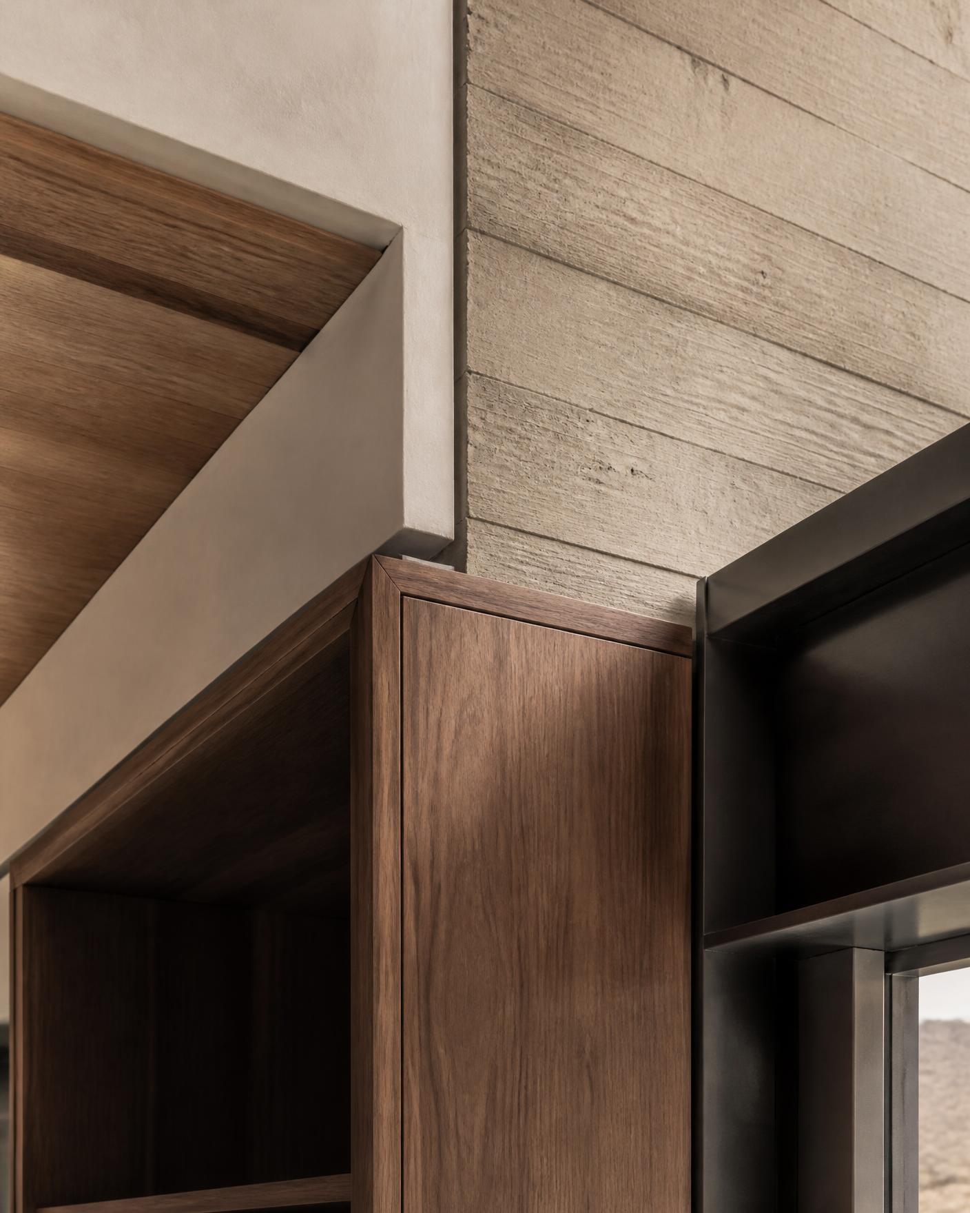 Detail of walnut millwork meeting board-formed concrete and blackened steel in a luxury Arizona custom home